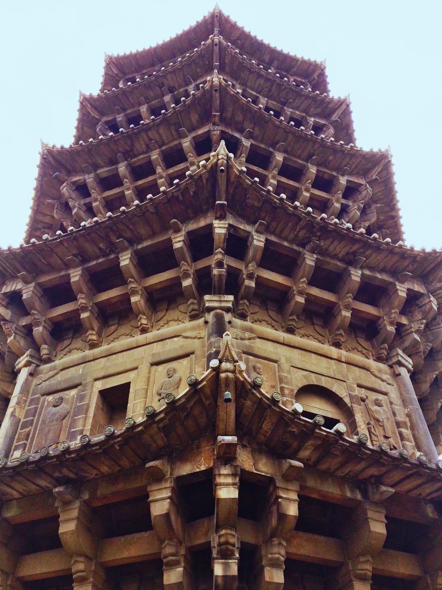 A multi-tiered temple with intricate carvings and a traditional roof structure.
