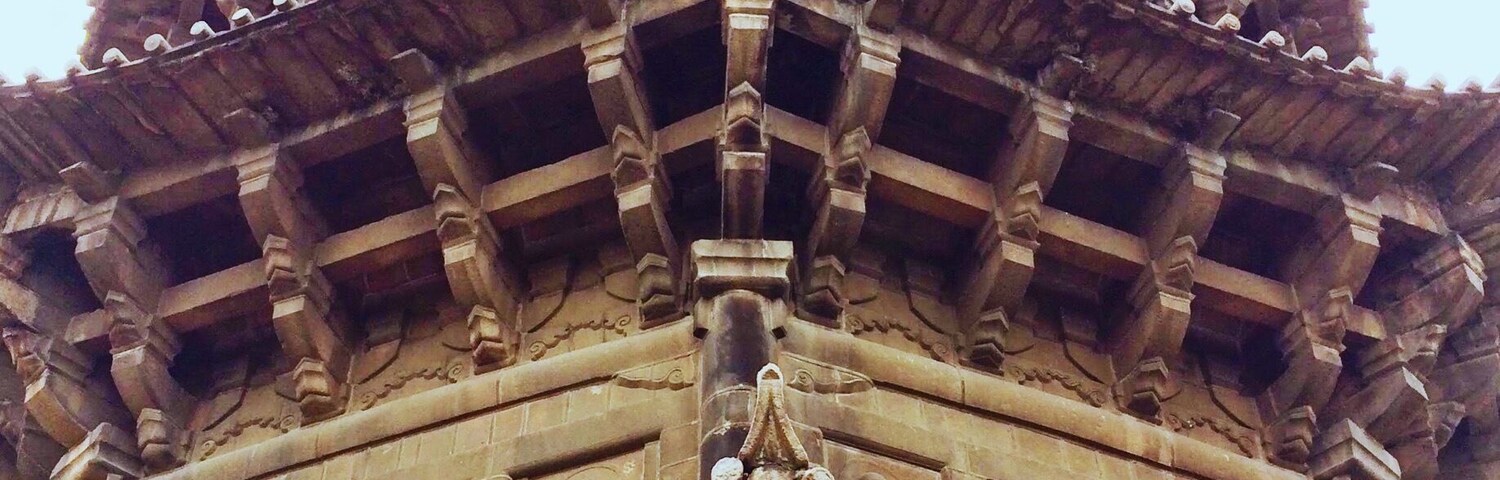 A multi-tiered temple with intricate carvings and a traditional roof structure.
