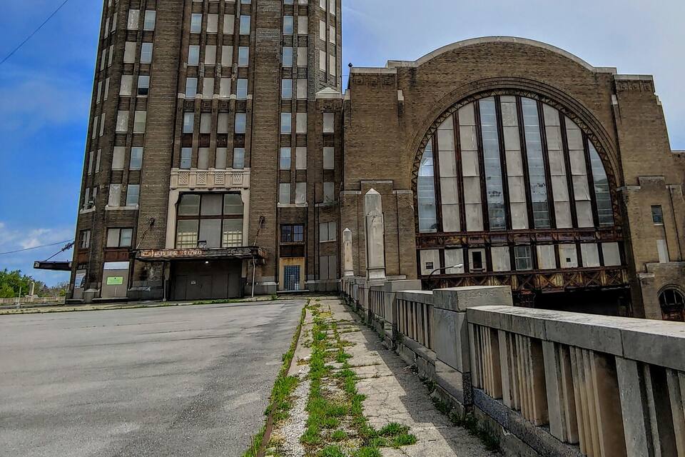 A tall, historic building with a large arched entrance and a clock on the side.