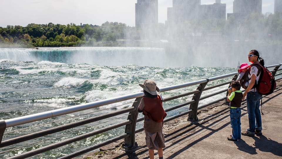 A waterfall, a city skyline, and a bridge railing.