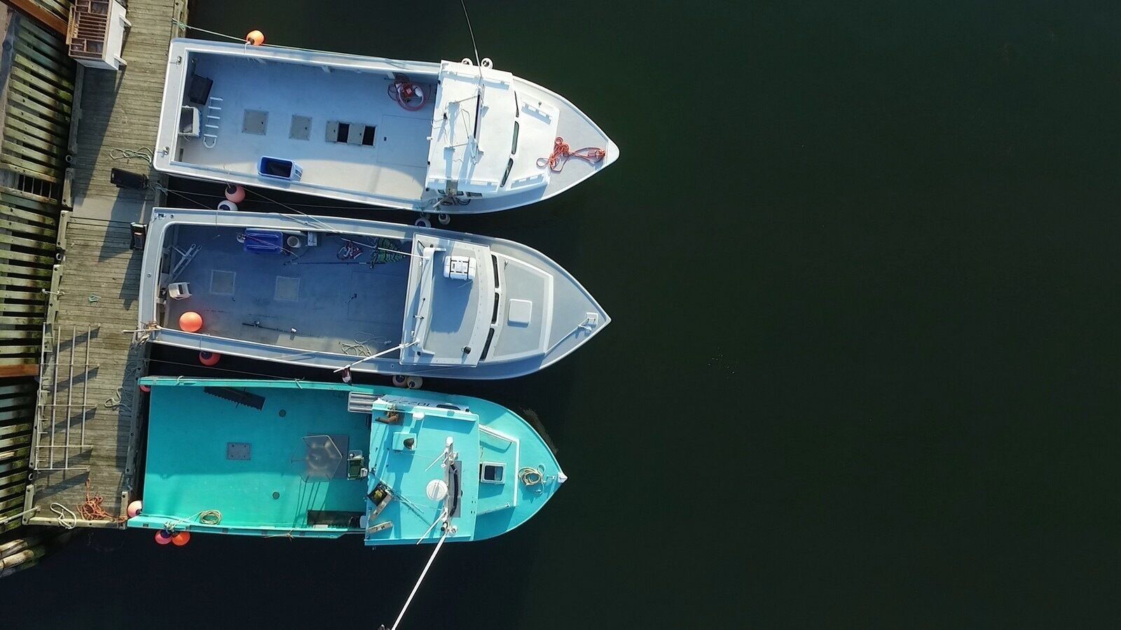 Three boats docked at a pier.