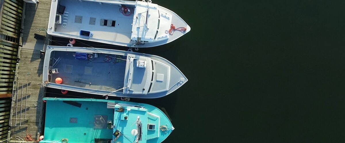 Three boats docked at a pier.