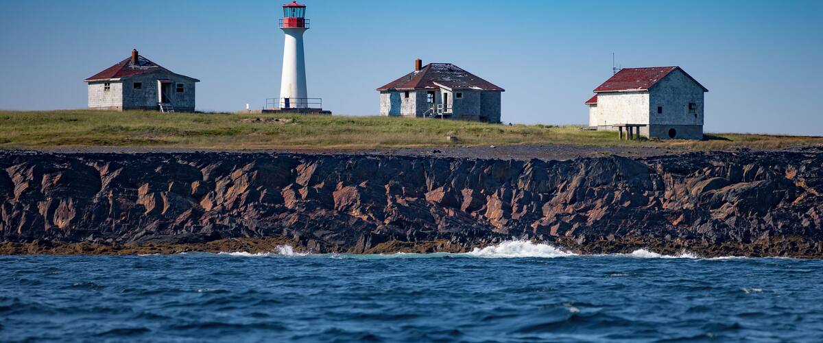 A wider view of the Cross Island Lighthouse, located in the North Atlantic Ocean, 8 miles Southeast of Lunenburg, NS