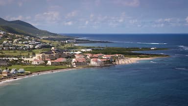 Un pueblo costero con edificios cerca de la playa y una montaña al fondo.