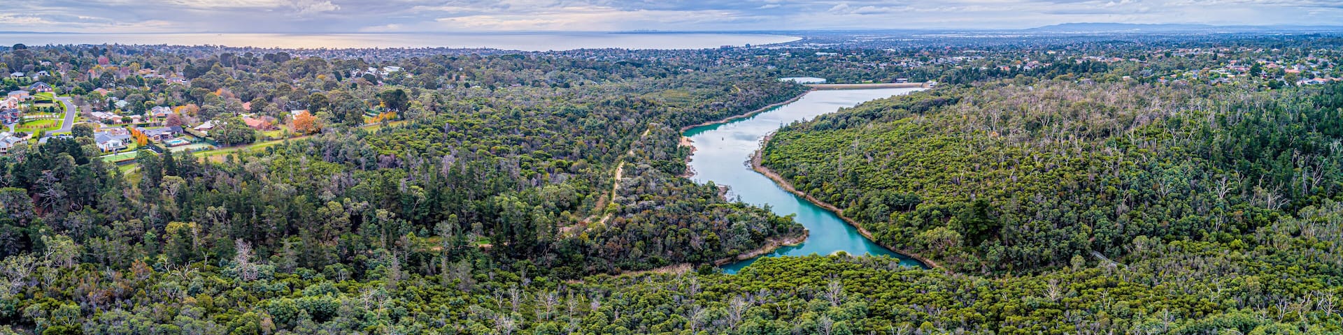 Wide aerial panorama of Frankston Reservoir with Port Phillip Bay on the horizon. Melbourne, Australia