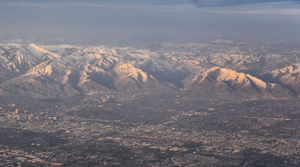 Aerial view from airplane of the Wasatch Front Rocky Mountain Range with snow capped peaks in winter including urban cities of Provo, Farmington Bountiful, Orem and Salt Lake City. Utah. United States