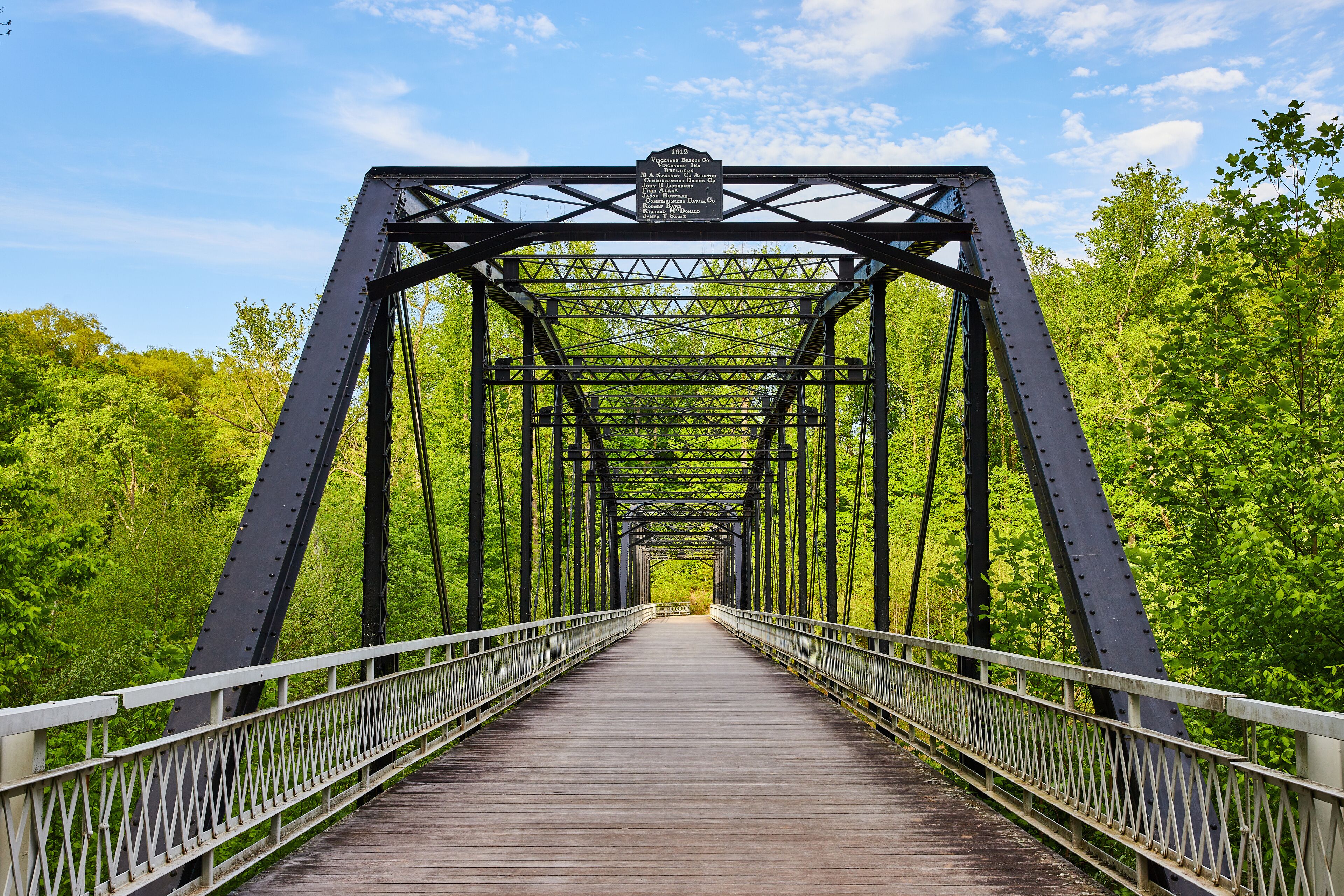 Blue sky, dark metal bridge, black, train bridge style, wooden plank board walkway