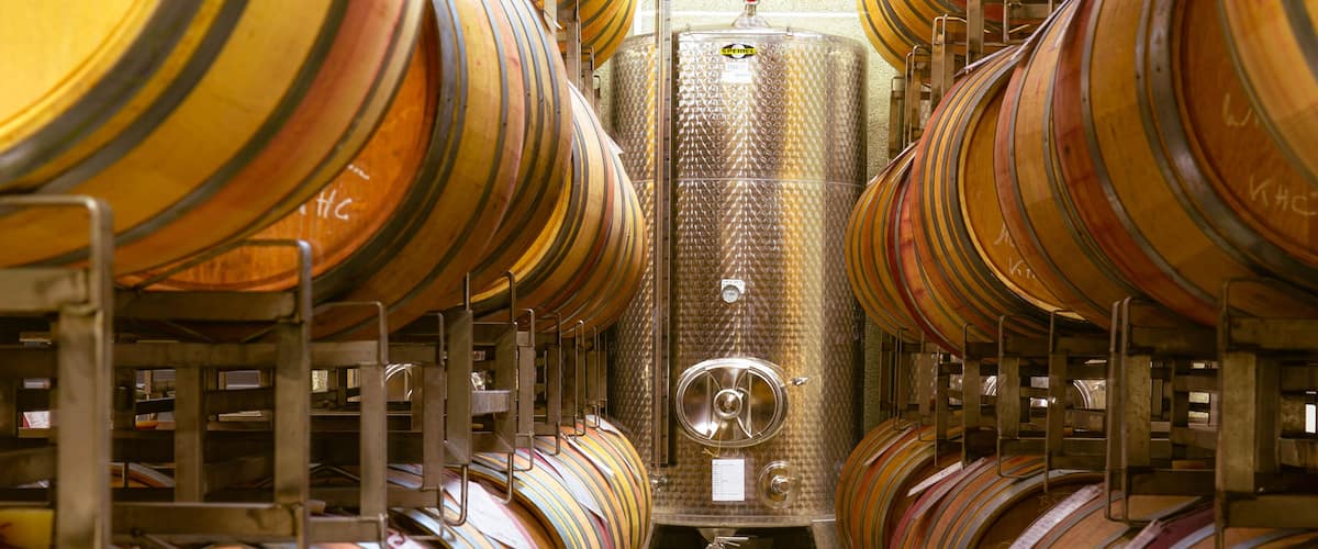 Rows of wooden barrels in a storage facility.