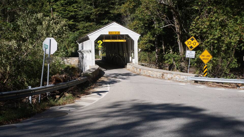 A covered bridge with a sign indicating a 10-foot clearance.