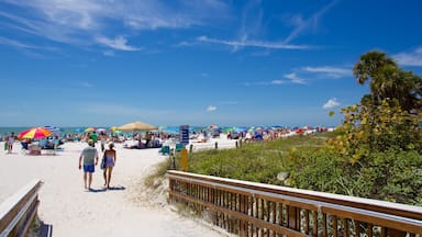 Fort Myers Beach mostrando una playa de arena y también un grupo pequeño de personas