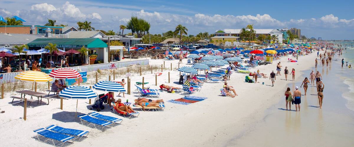 Una playa concurrida con numerosos sombrillas y sillas de playa.