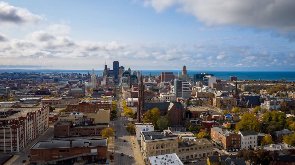 A cityscape with a prominent skyscraper, a historic church, and a waterfront.