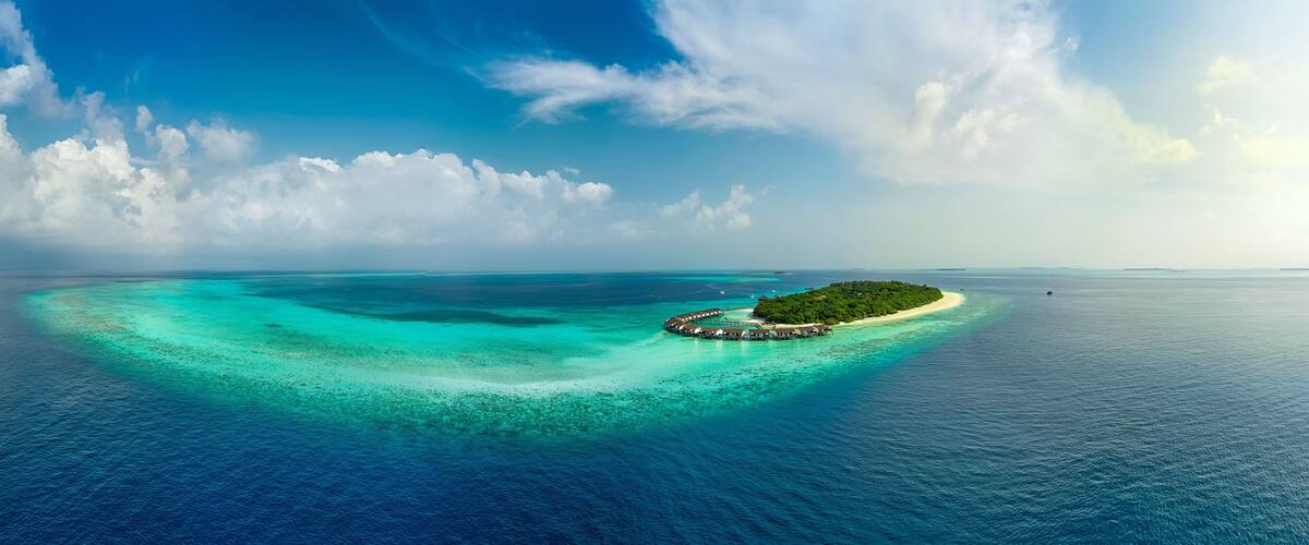 A turquoise lagoon with a small island featuring a resort.