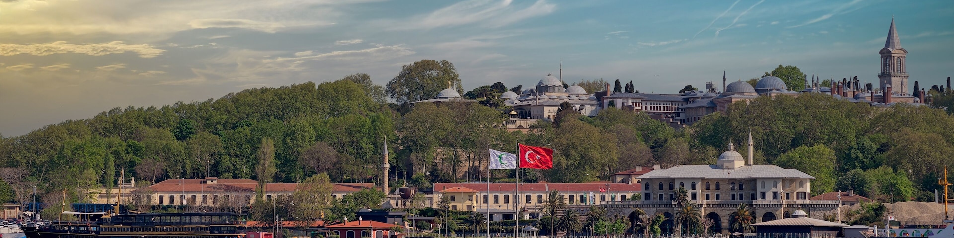 View from Galataport overlooking Bosphorus strait with sailing ferry boat and Topkapi Palace in the far end before sunset, Istanbul, Turkey