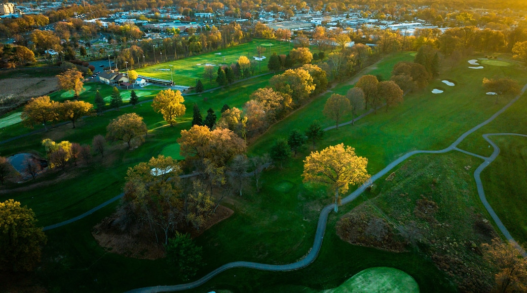 Vista aerea di un campo da golf con una città sullo sfondo.