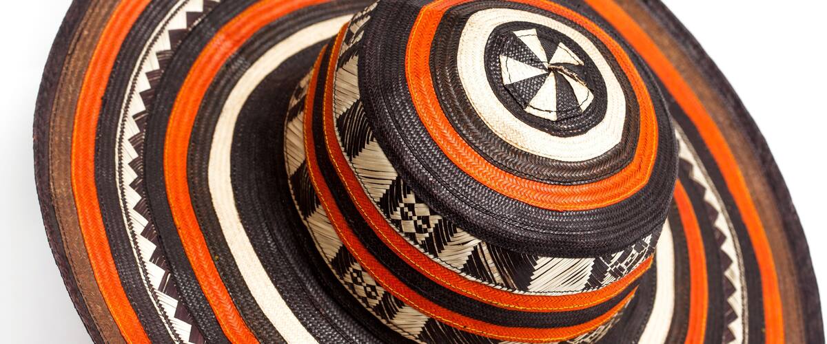A traditional woven hat with multiple bands of black, white, and orange colors.