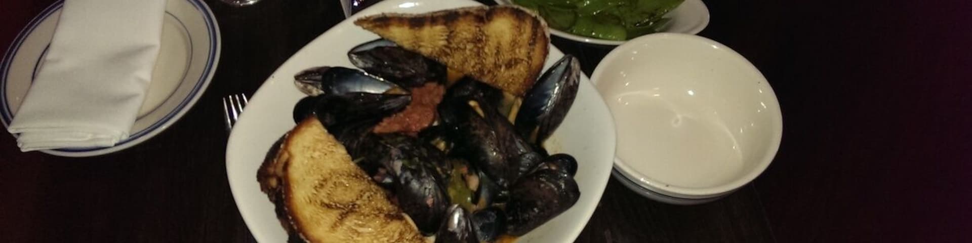 The mussel appetizer here is PLENTY for one person's entree, and sooo tasty. It has some kick with spicy chorizo and jalapenos. They serve a big helping of hearty bread to soak up all the browth. Great beer list here too.