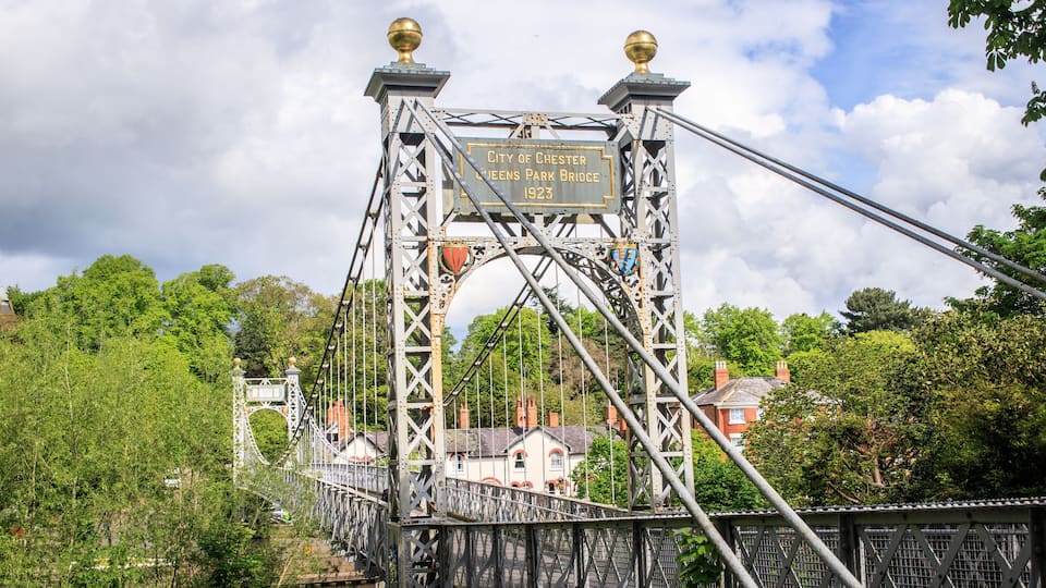 A bridge with a plaque reading "City of Chester Queens Park Bridge 1923".