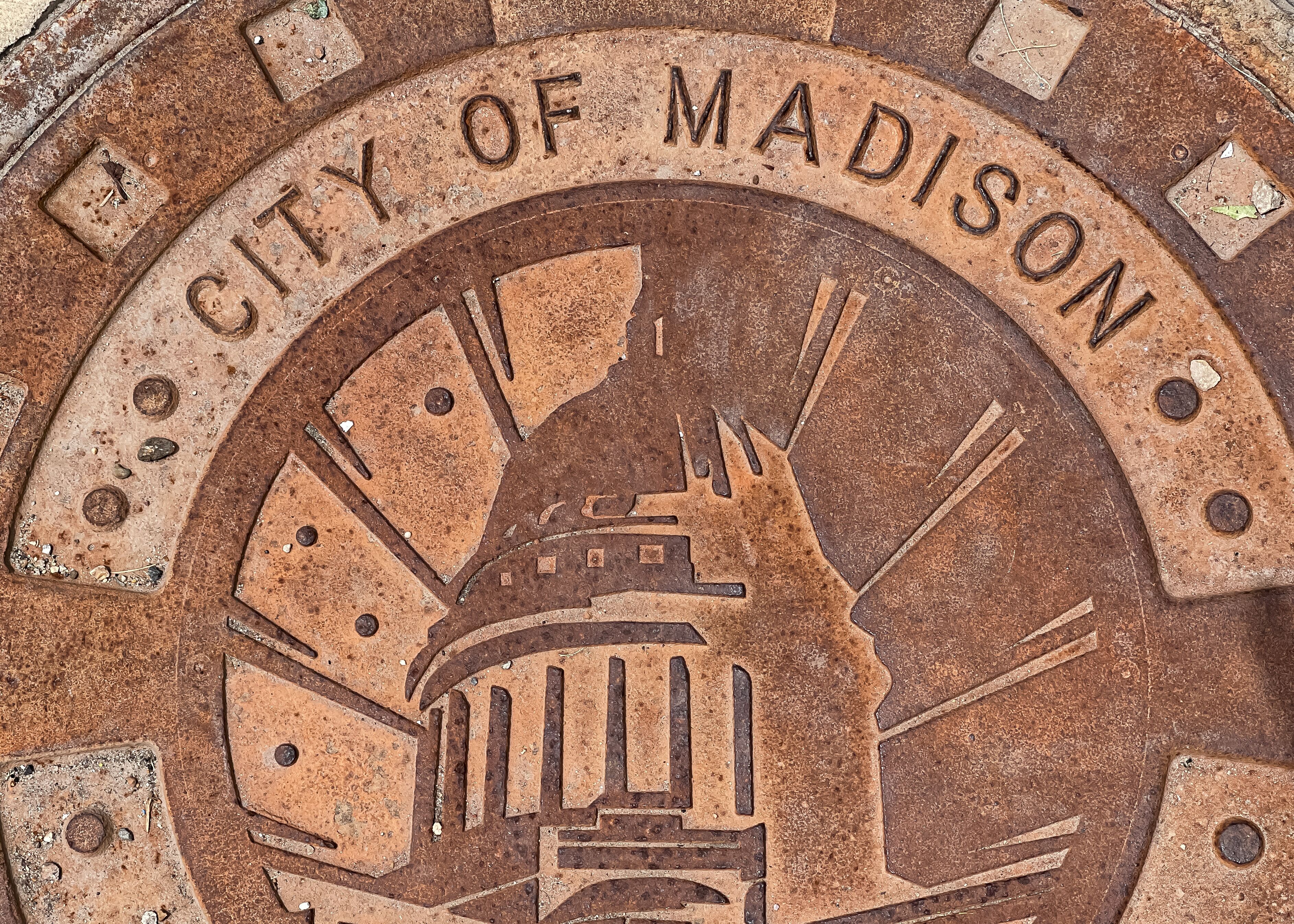 City of Madison sign on rusty man hole cover.