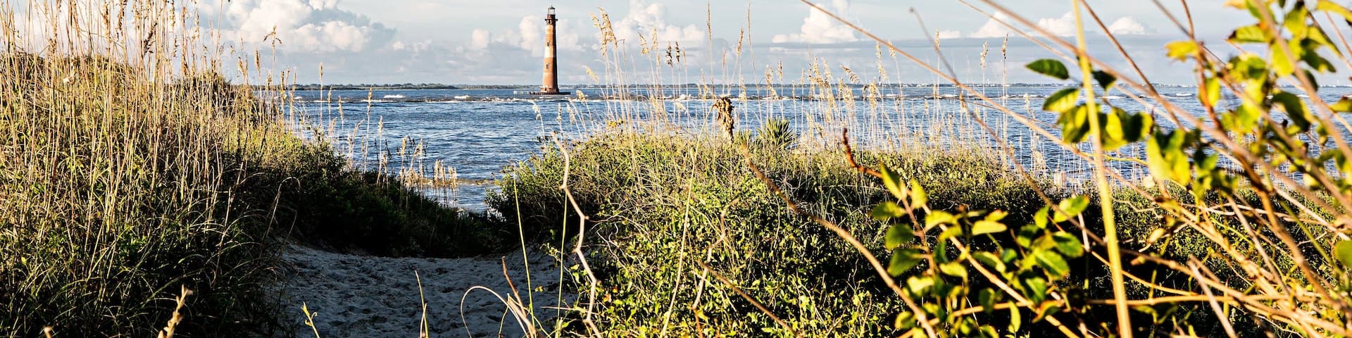 Folly Beach which includes a lighthouse and general coastal views