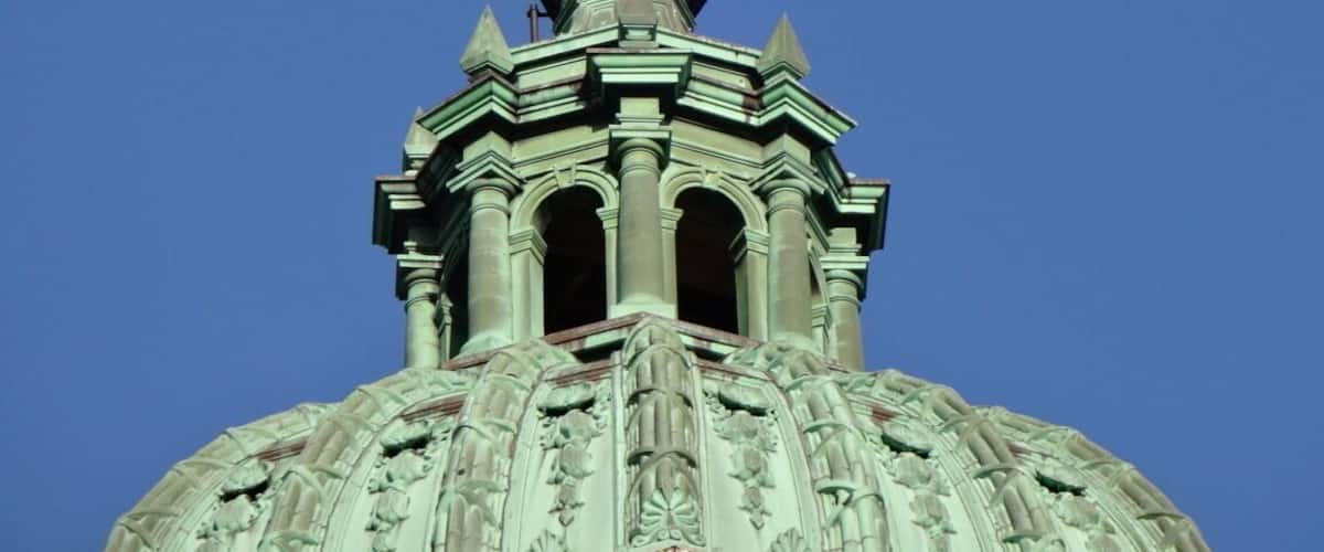 A statue of Lady Justice atop a domed building with intricate architectural details.