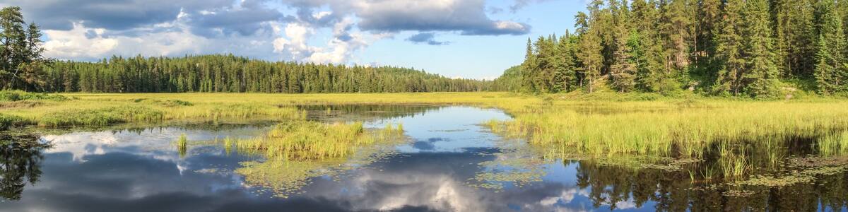 Blue mirror lake reflections of clouds and landscape. Sudbury, Ontario, Canada.