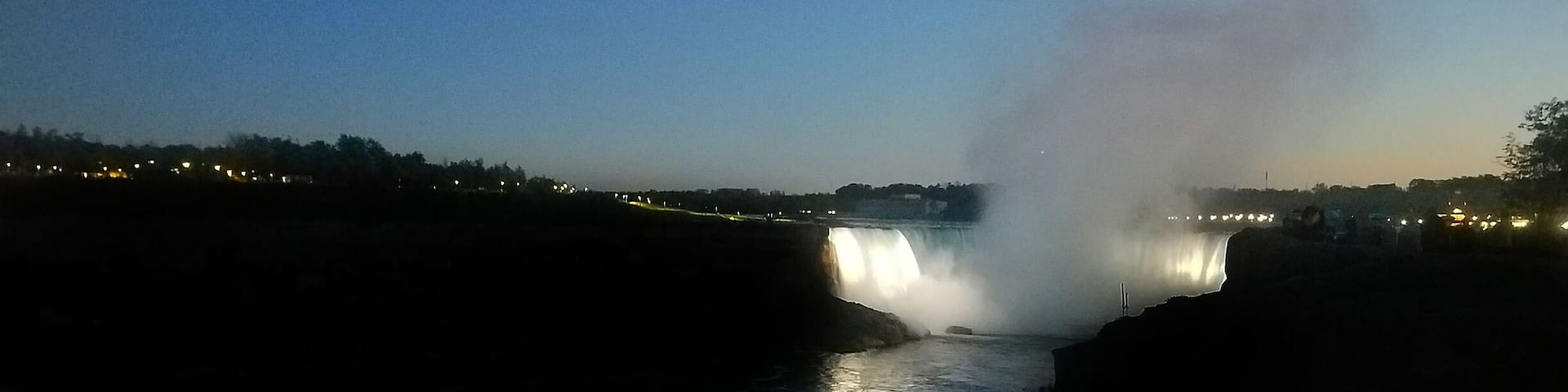 A waterfall at dusk with water cascading down a rocky cliff.