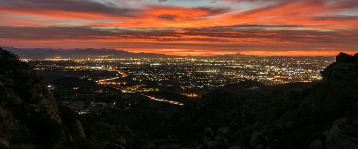 A cityscape at dusk with a vibrant sunset sky.