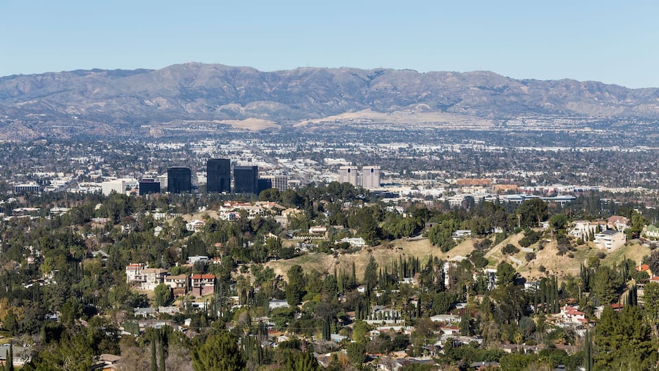 A cityscape with mountains in the background.