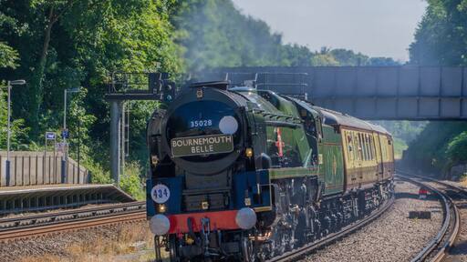 Clan Line. A Merchant Navy Class Steam locomotive speeds through Farnborough Station , Hampshire on 5th July, 2017. with The Bournemouth Belle