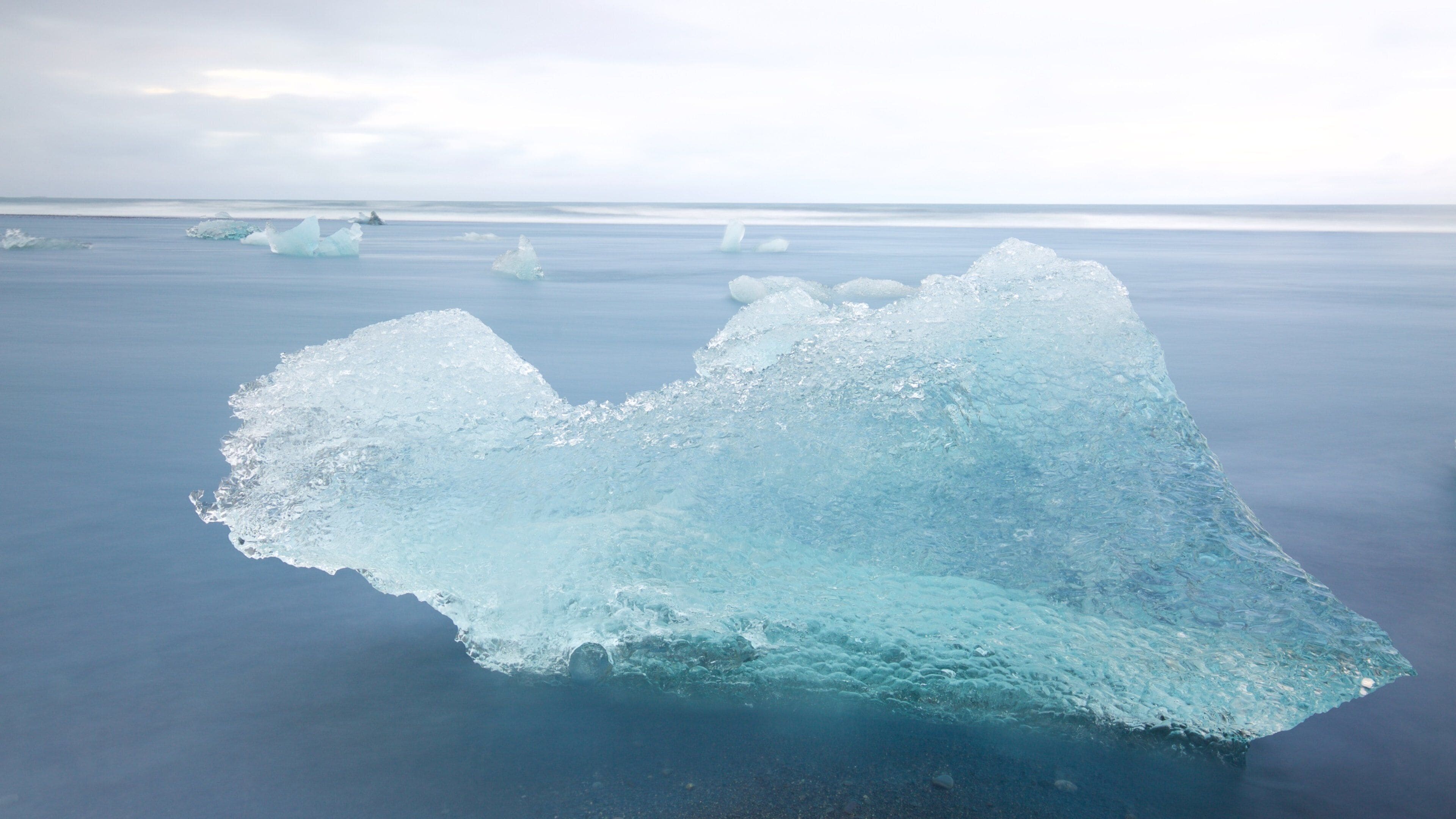 A large iceberg floating in calm ocean waters.