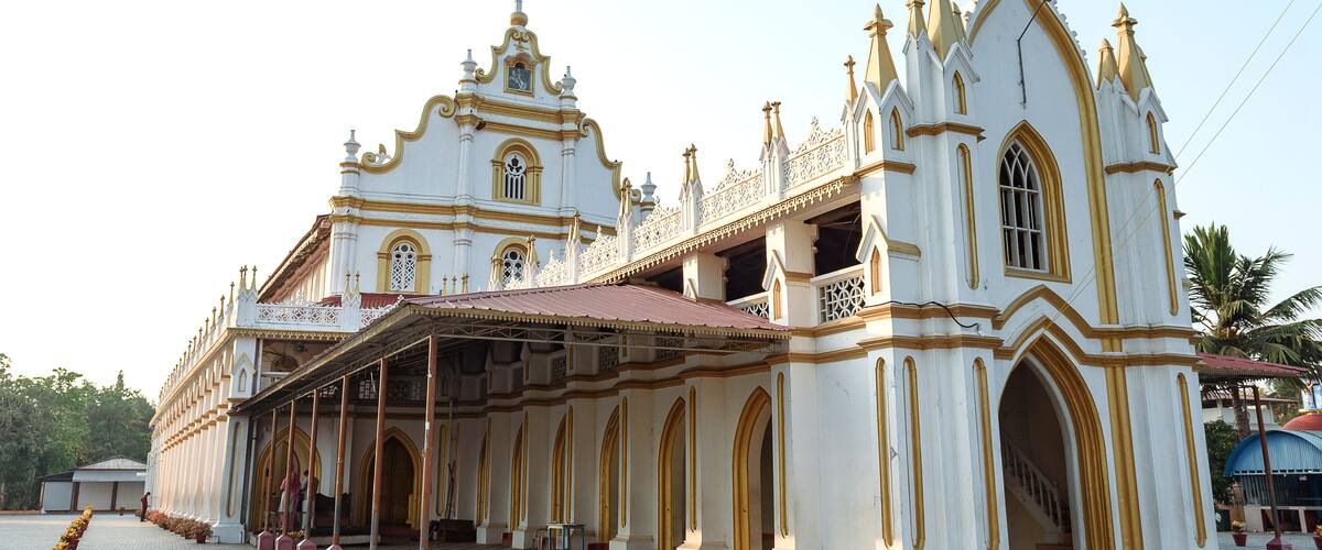 A large white church with gold accents and a cross on top.