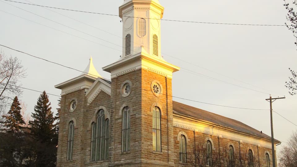 A church with a tall steeple and arched windows.