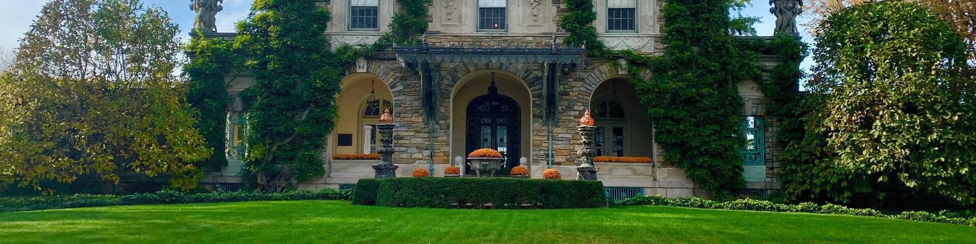 A large, historic building with a symmetrical facade, arched windows, and a central entrance with a decorative pediment.
