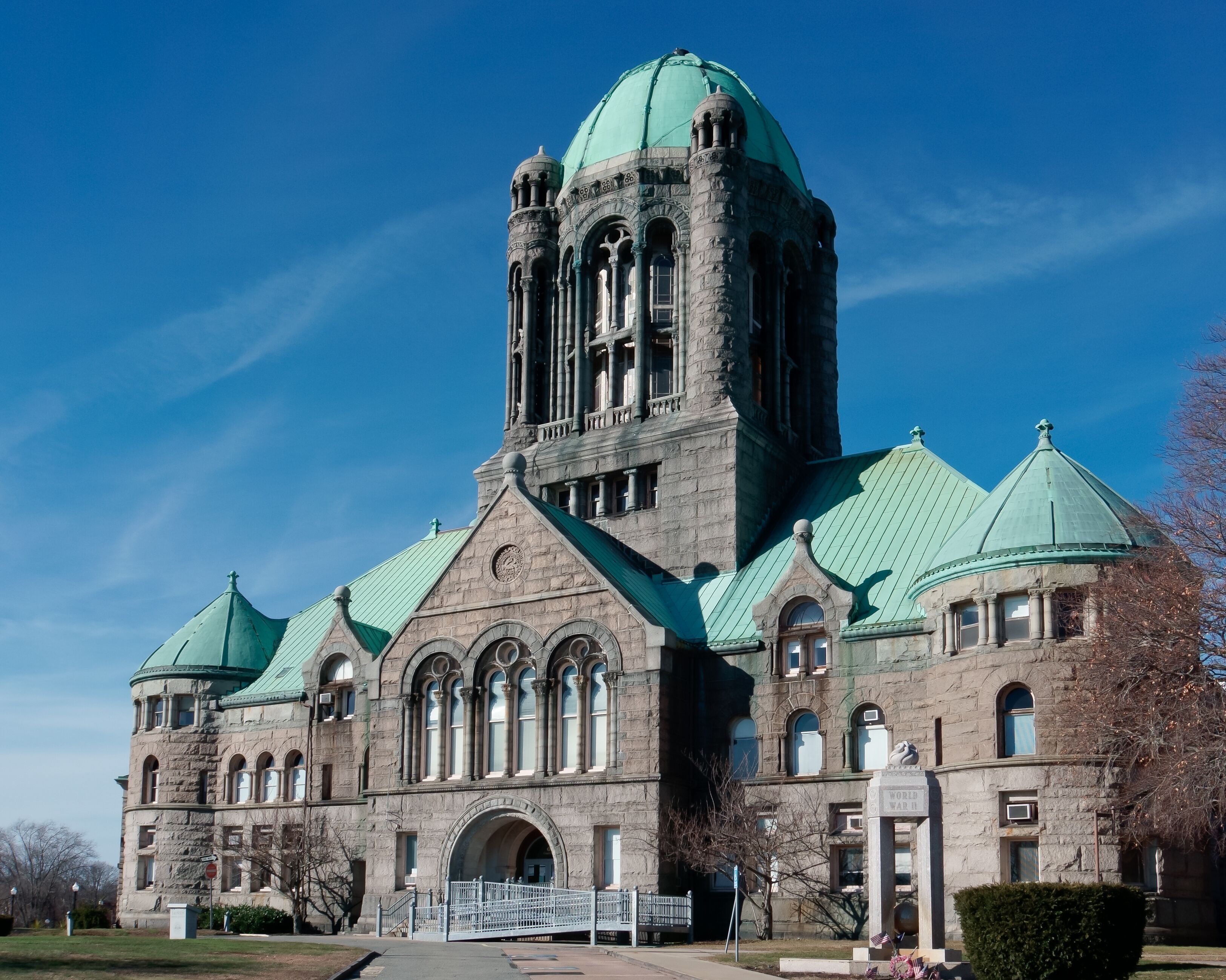 A large stone building with a green dome and arched windows.