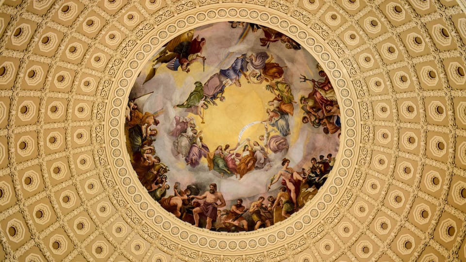 A detailed fresco mural on a domed ceiling with geometric patterns and figures.