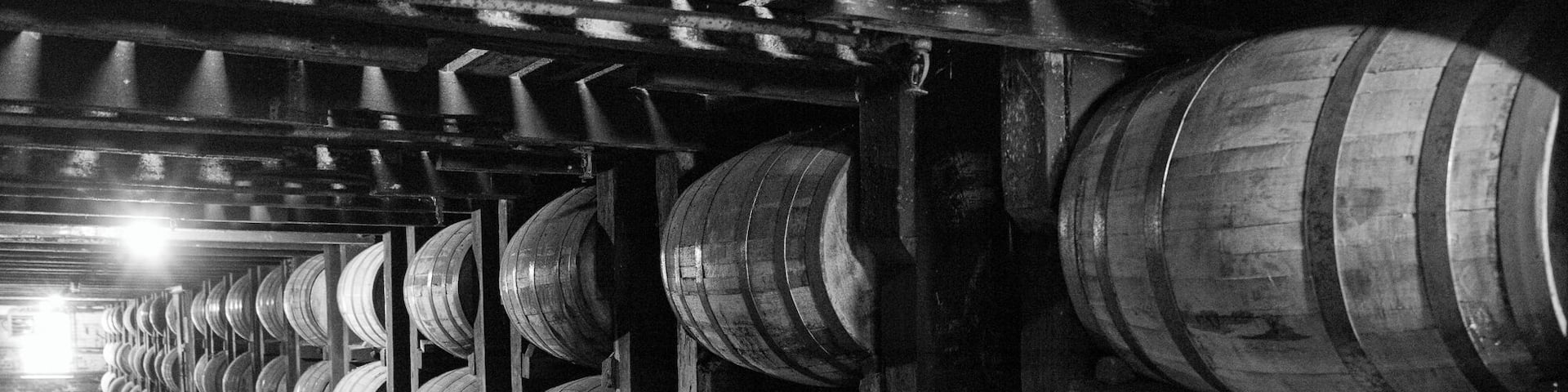 A warehouse with rows of wooden barrels.