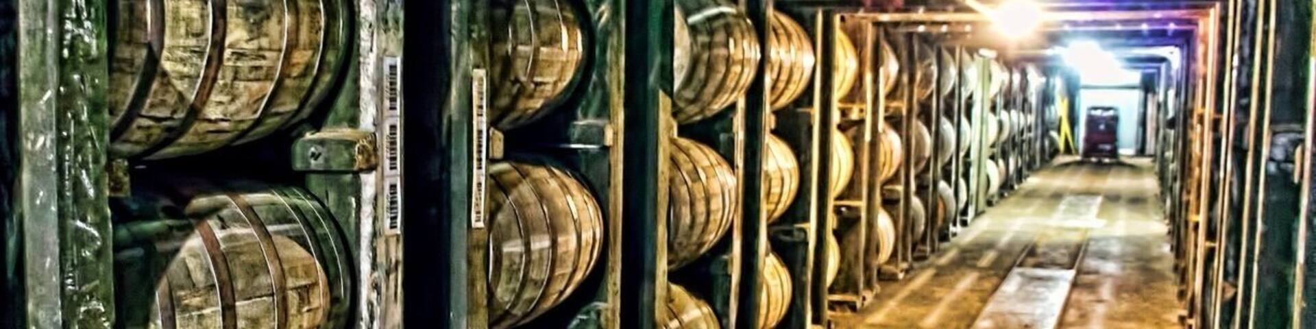 A warehouse with rows of wooden barrels.
