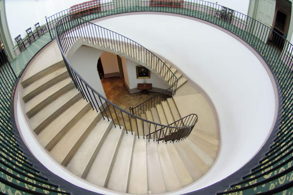 A spiral staircase with a white interior and green accents.