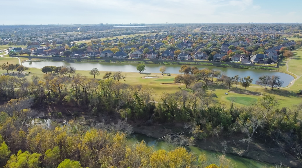 Top view country club golf course and lakeside residential houses near nature park with fall foliage in Carrollton, Texas, USA