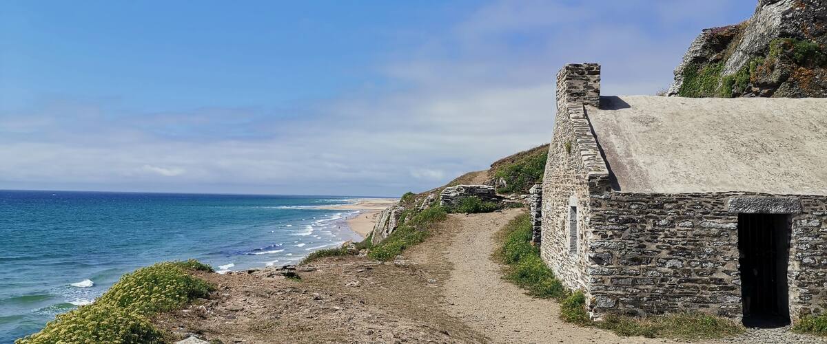 A coastal path leading to a stone building by the sea.