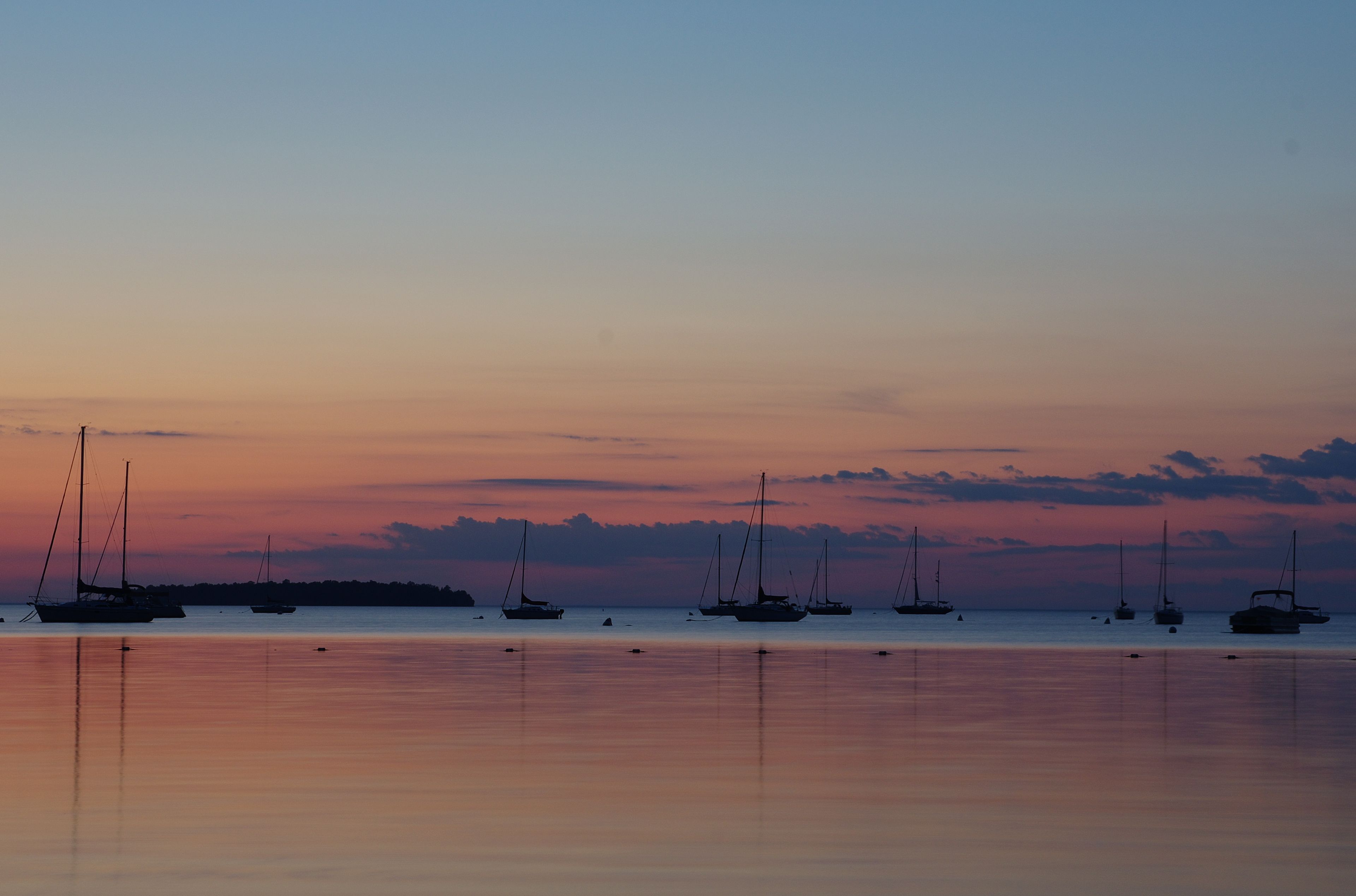 Sunset over lake with sail boats