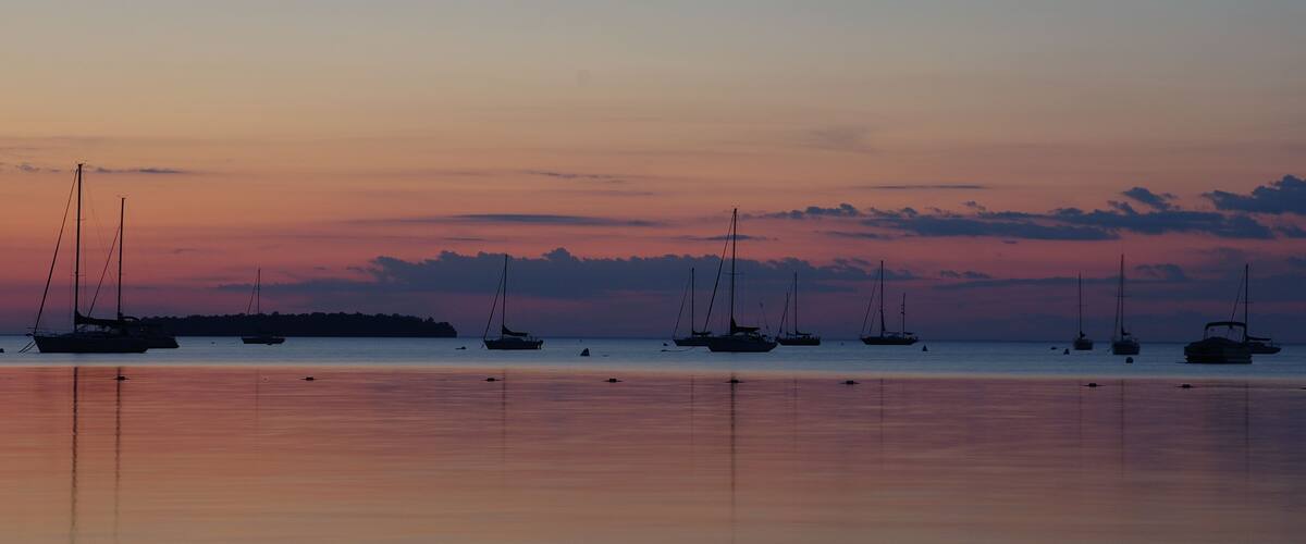 Sunset over lake with sail boats