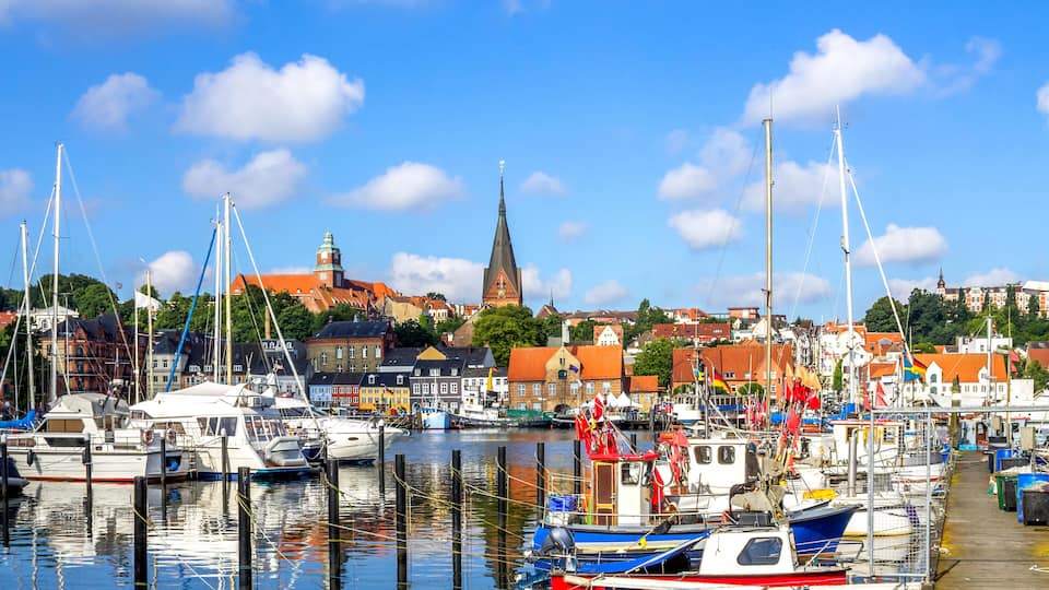 A harbor with boats, a church, and colorful buildings.