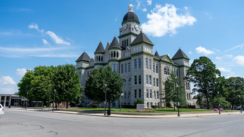 A large, historic building with multiple towers and a clock tower.