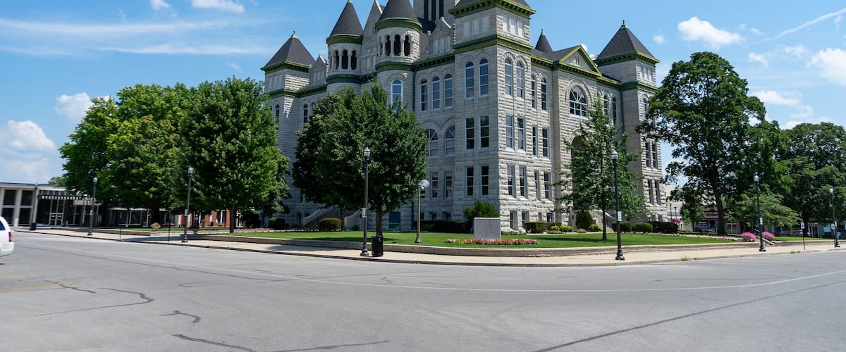 A large, historic building with multiple towers and a clock tower.