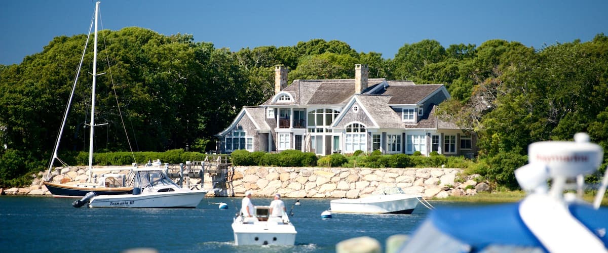 A large house by the water with several boats.