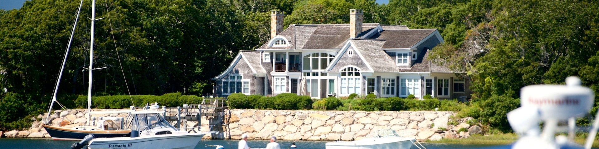 A large house by the water with several boats.