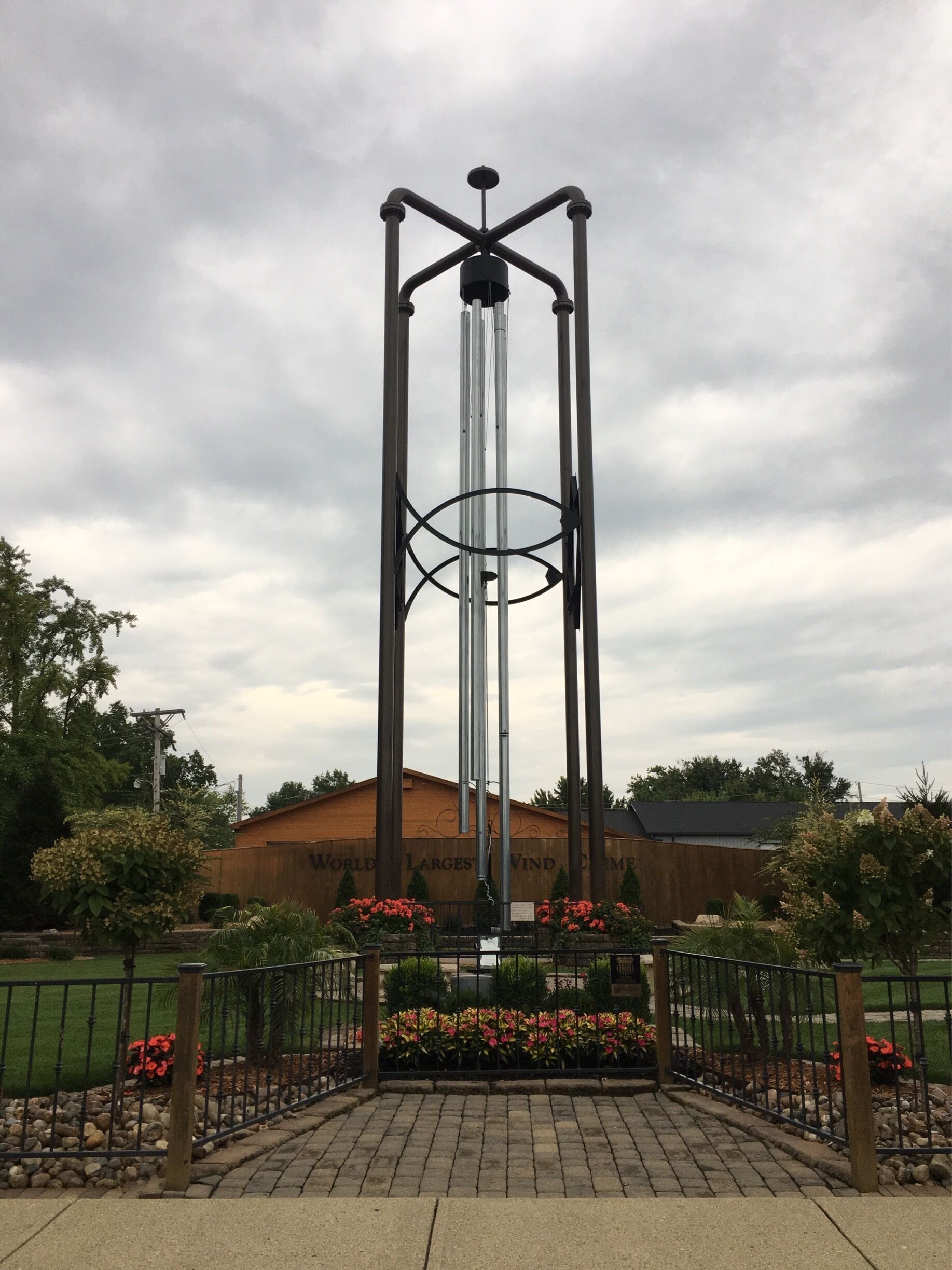 A tall, metallic wind turbine structure with a cylindrical tower and horizontal beams.