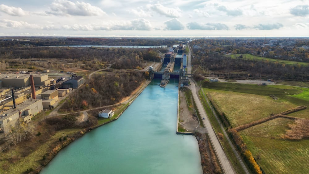 Aerial over the Welland Canal, part of the St. Lawrence Seaway and Great Lakes Waterway in St. Catharines, Ontario, Canada. Looking south towards lock 5 in Thorold. Autumn in November 2024.